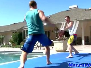 Gay muscular jocks sword fighting by the pool